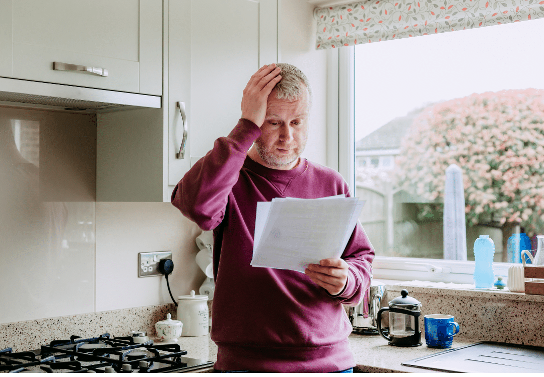 Man looking stressed while looking at bills Man looking stressed while looking at bills