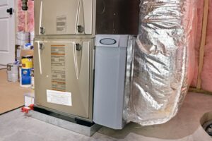 A high efficiency furnace and ductwork in a basement utility room.